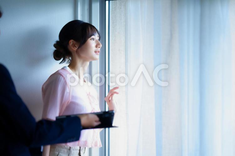 遠くを見ている女性と誰かの手元 女性,人物,若者の写真素材