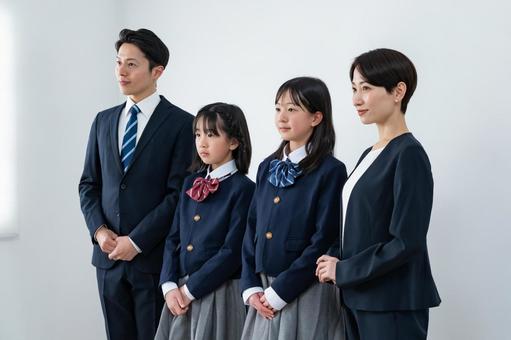 スーツを着た男女と制服を着た女の子二人 入学式,父母,母親の写真素材
