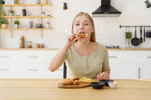 フライドチキンを食べる女性 フライドチキンを食べる女性 女性,人物,座るの写真素材