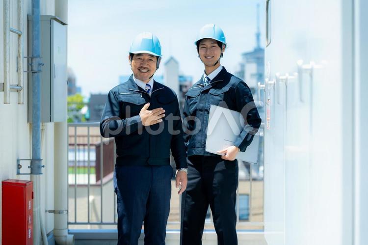 現場で打ち合わせする作業服のビジネスマン 作業服,笑顔,打ち合わせの写真素材