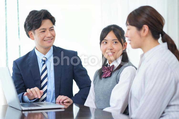 ノートパソコンを見ている女子生徒とお母さんと家庭教師 塾,人物,女の子の写真素材
