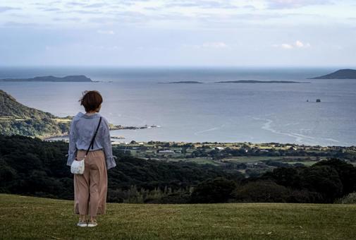 ＜素材＞山頂を散歩する女性の後ろ姿 女性,海,空の写真素材
