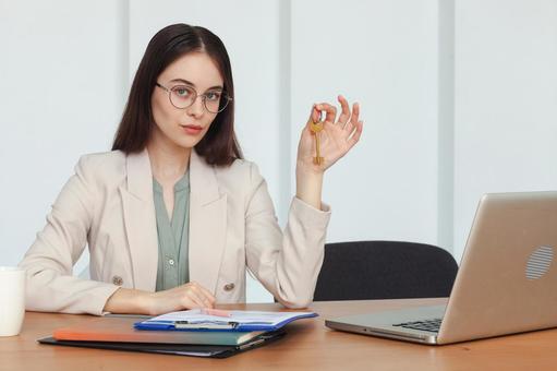 鍵をもってこちらを見る女性スタッフ 保険業,事務職,接客業の写真素材