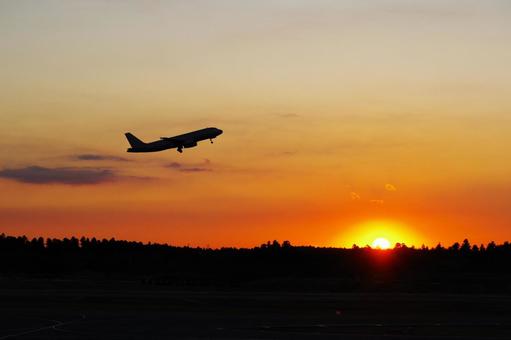 離陸する飛行機と夕焼け 離陸する飛行機と夕焼けの写真