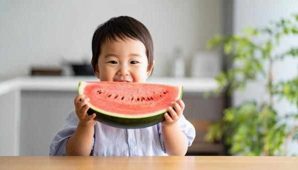 スイカを手に持つ子ども スイカを手に持つ子どもの写真