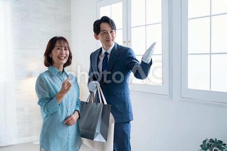 買い物の袋を持つスーツの男性と女性客 ショッピング,コンシェルジュ,ブランドの写真素材