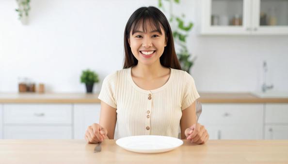 食後、空になったお皿を前に笑顔の女性の写真