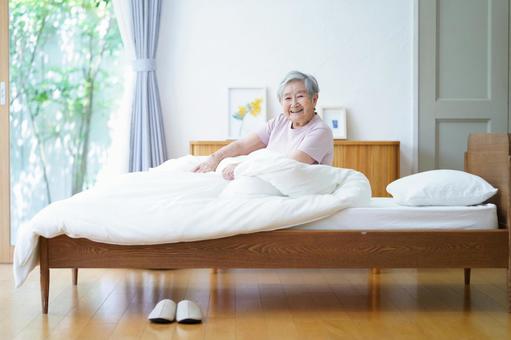 起床し笑顔の高齢女性 女性,ベッド,座るの写真素材