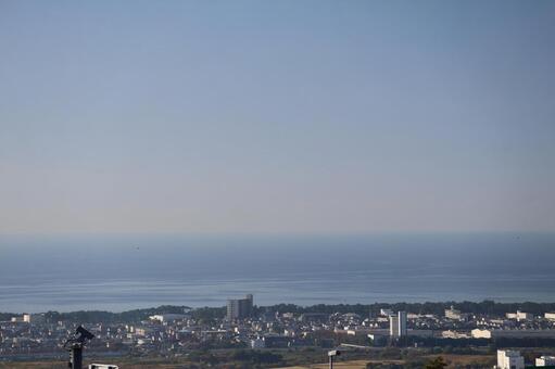畑と街並みと松林と海と水平線と青空の風景 畑,街並み,松林の写真素材