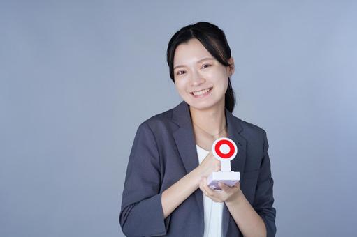 グレーの服の女性が丸札を持つ 女性,マル,正解の写真素材