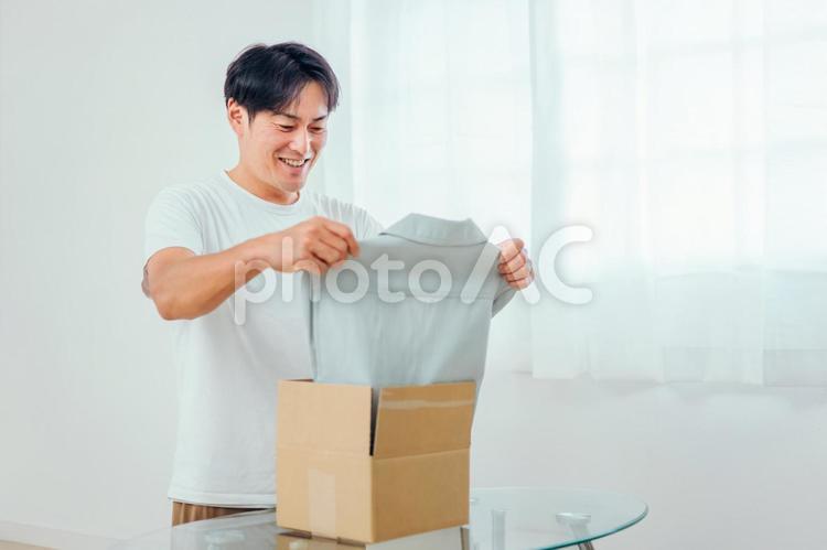 通販で洋服を買った男性 通販,宅急便,ネットショッピングの写真素材