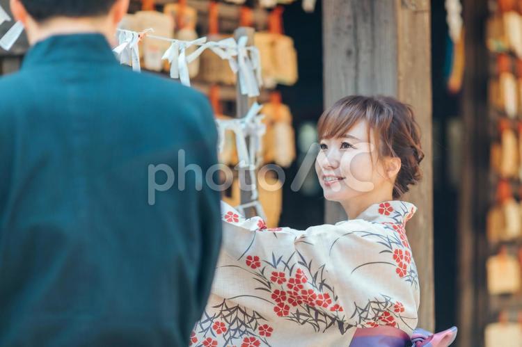 おみくじを結ぶ浴衣姿の男女 おみくじ,願い事,運勢の写真素材