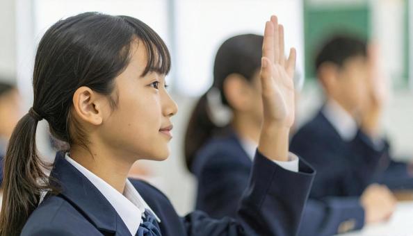 学校の授業中、手をあげる子供たち 学校の授業中、手をあげる子供たちの写真