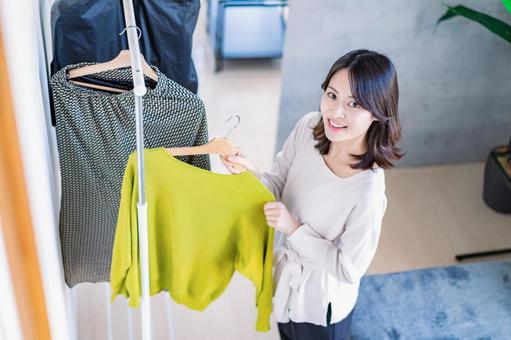自宅で服を選ぶ若い女性 自宅で服を選ぶ若い女性 ハンガー,店員,リサイクルの写真素材