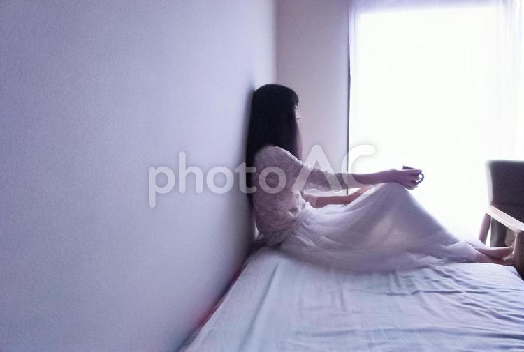 窓の外を眺める女性(横長) 女性,休む,悩むの写真素材