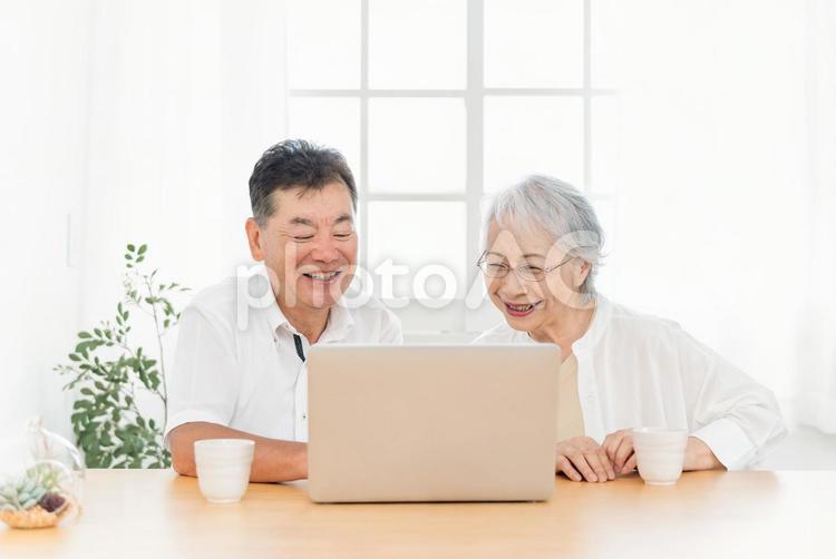 ノートパソコンを見る高齢者夫婦（笑顔） 高齢者,パソコン,光テレビの写真素材
