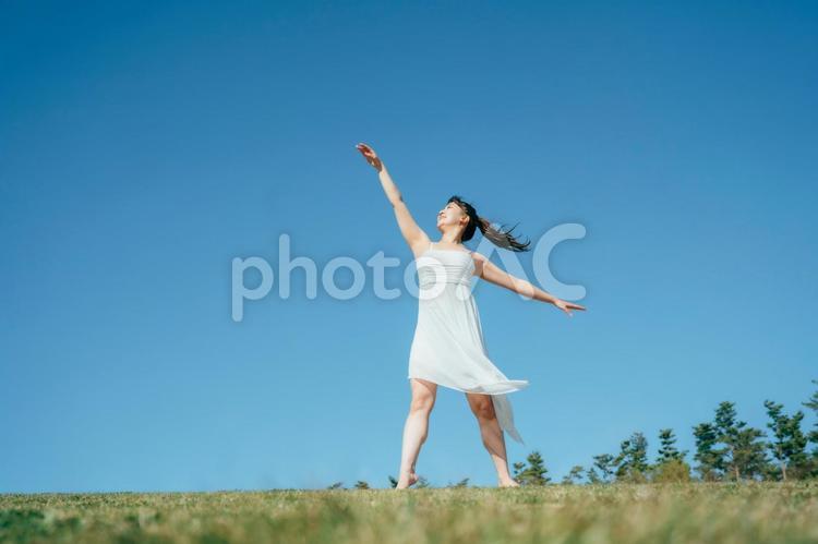空と白いワンピースの踊る女性 女性,空,美容の写真素材