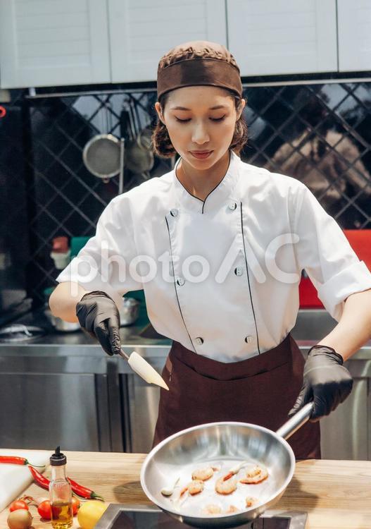 フライパンでエビを調理する女性シェフ キュイジーヌ,キッチン,厨房の写真素材