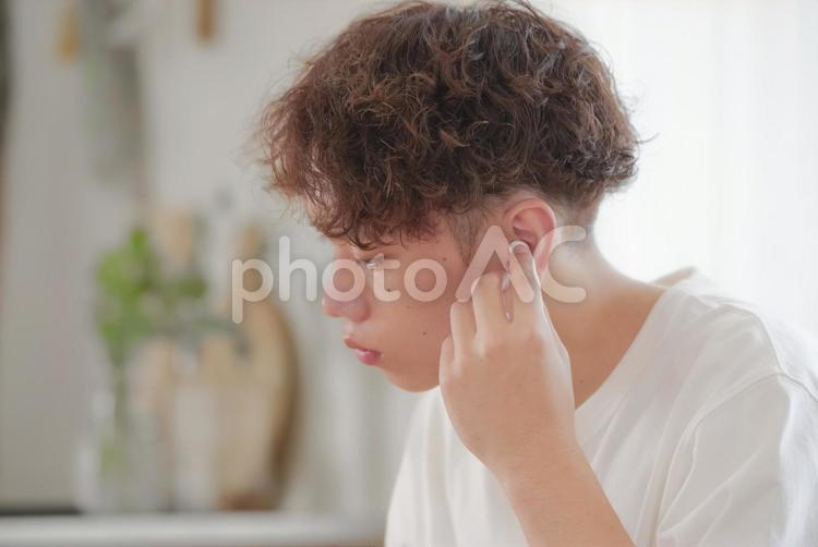 ワイヤレスイヤホンをつける若い男性 イヤホン,ワイヤレスイヤホン,音楽の写真素材