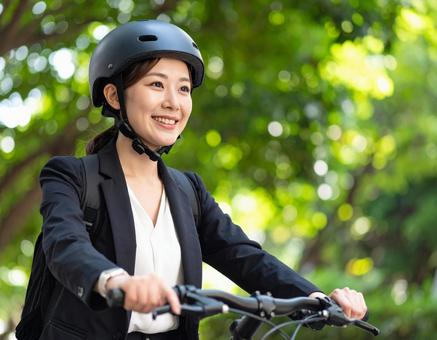 ヘルメット被って自転車に乗る女性 ヘルメット被って自転車に乗る女性の写真