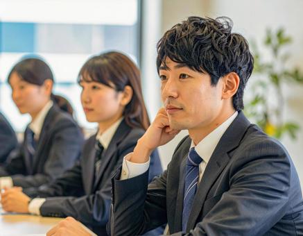 真剣な表情で会議に臨む若手ビジネスマン 真剣な表情で会議に臨む若手ビジネスマンの写真