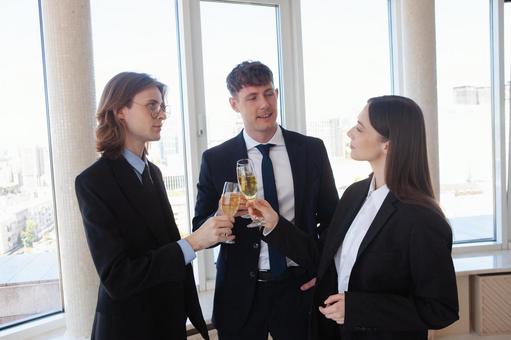 シャンパンで乾杯するスーツの3人 男女,乾杯,外国人の写真素材