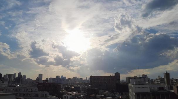 都会　高所より　天気雨の太陽の写真