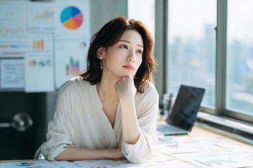 資料を見て悩むビジネス女性 資料を見て悩むビジネス女性の写真