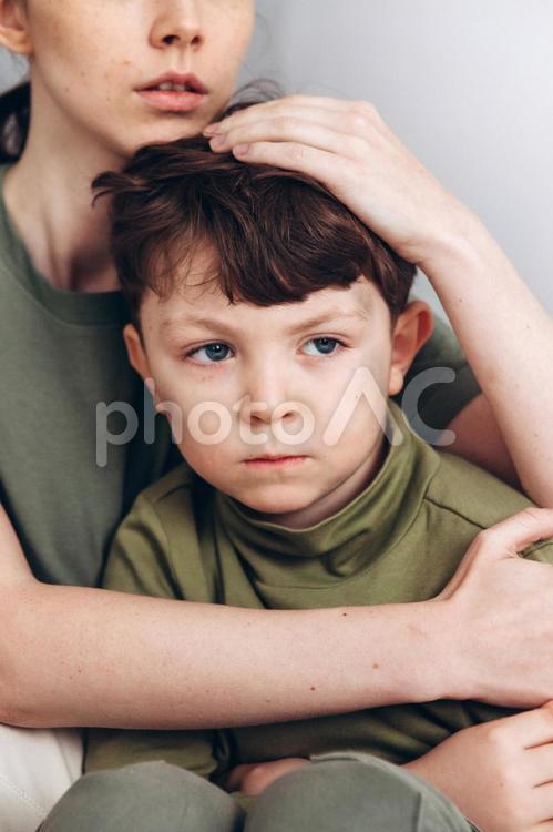 怖そうな息子を抱きしめる母親 男の子,母親,親子の写真素材
