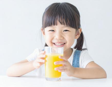 オレンジジュースを飲む子供 オレンジジュースを飲む子供の写真