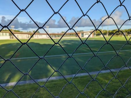 フェンス越しのサッカー場 フェンス越しのサッカー場の写真