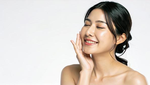 ビューティー　肌を満足げに触る女性の写真