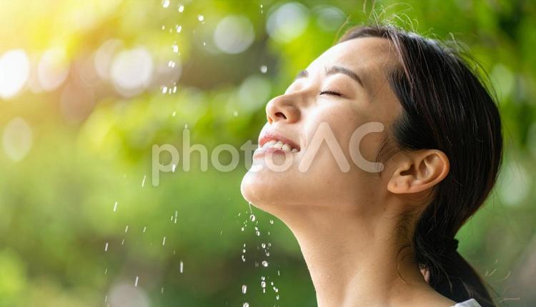 汗をかいて顔に水を浴びる女性 水,濡れる,浴びるの写真素材