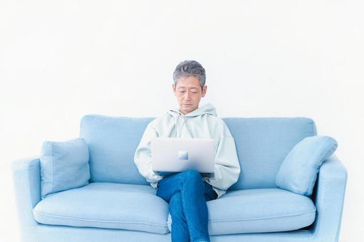 自宅でパソコンを使う高齢の男性 クリエイティブ,老人,オンラインの写真素材