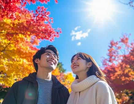 秋の紅葉を鑑賞する笑顔の若いカップル 秋の紅葉を鑑賞する笑顔の若いカップルの写真