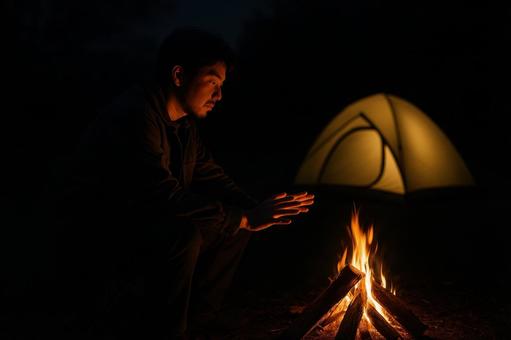 夜の焚き火にあたる男性 夜の焚き火にあたる男性の写真