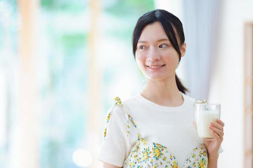 牛乳を持ち振り向くポニーテールの女性の写真