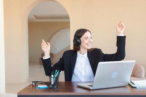 ベッドホンを装着し笑う女性 女性,外国人,ノートパソコンの写真素材