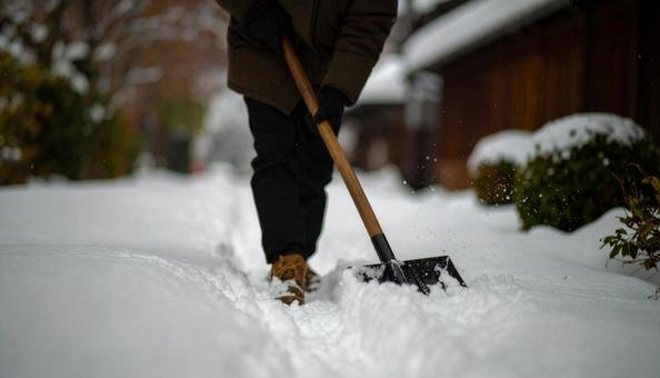 大雪が降った日の翌日の朝に雪かきする男性 大雪が降った日の翌日の朝に雪かきする男性 の写真
