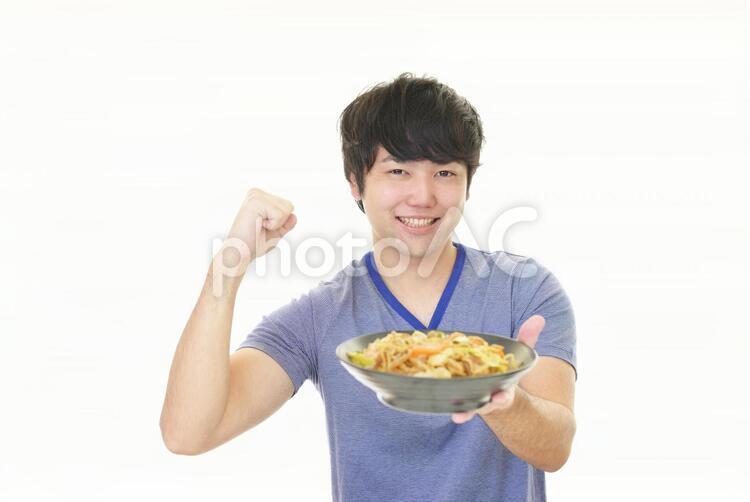 料理を持つ笑顔の男性 男性,男,焼きそばの写真素材
