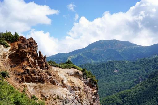 夏の青空とそびえ立つ断崖の写真