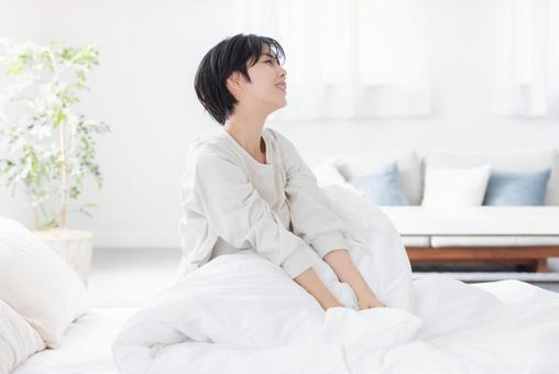 寝起きの女性 寝起きの女性 女性,寝起き,ベッドの写真素材