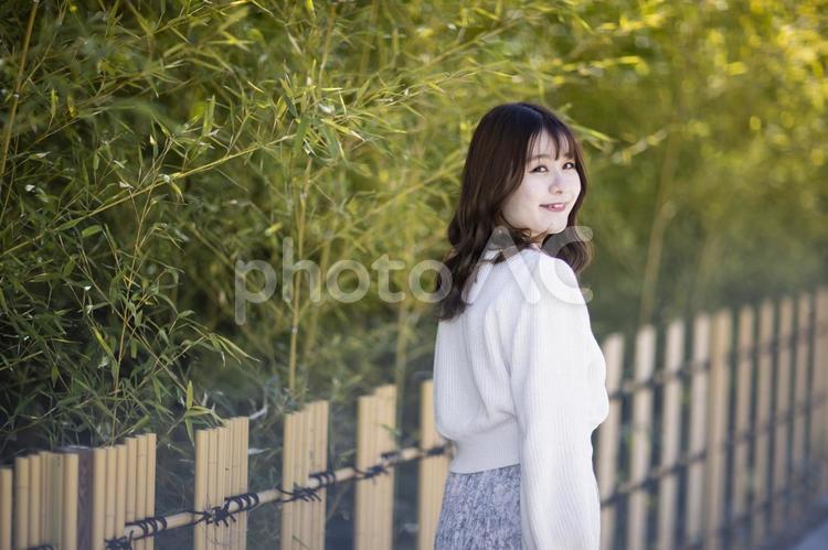 振り返りながら微笑む若い女性 女性,女,レディの写真素材