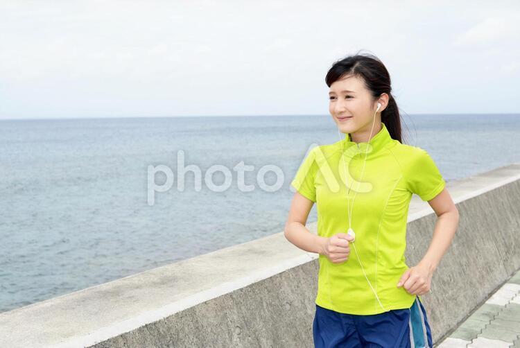 海岸でジョギングを楽しむ女性 女性,女,運動の写真素材