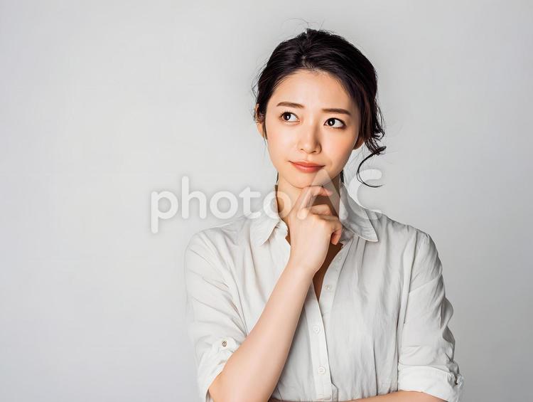 ビジネスシーンの考え込む女性。白背景 考え込む,日本人,女性の写真素材