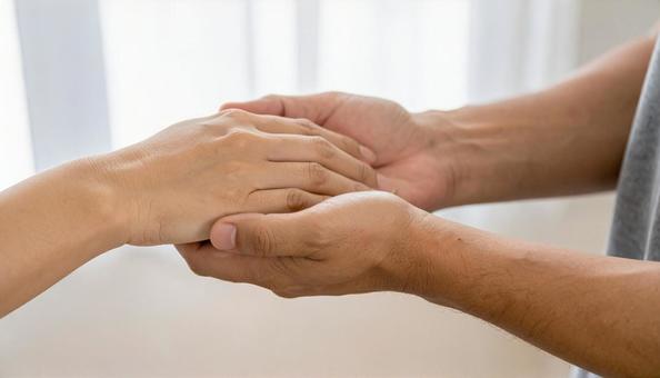 手を取り合う男女の写真