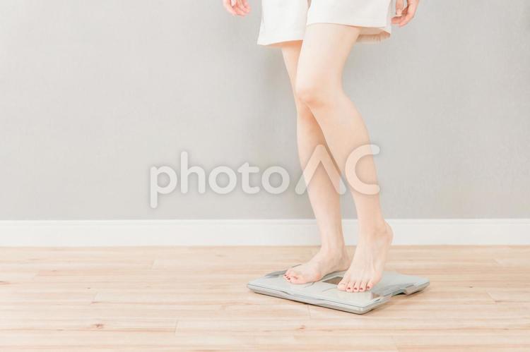 体重計に乗るスリムなアジア人女性 体重計,ダイエット,スリムの写真素材
