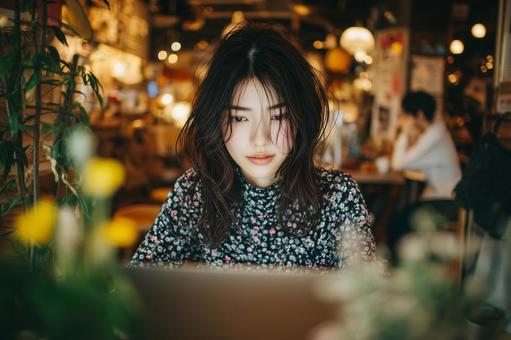 カフェでノートパソコンを使用する女性の写真