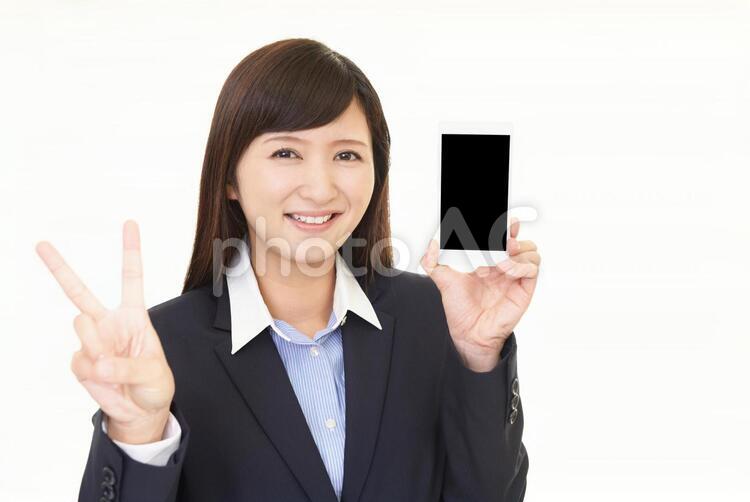 スマートフォンを持つ笑顔の女性 女性,ビジネスウーマン,女の写真素材