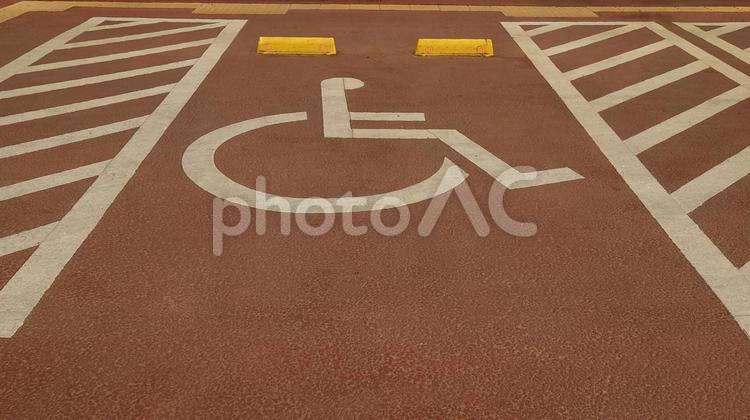 駐車場の車椅子専用駐車スペース・赤カラー 駐車場,車椅子マーク,バリアフリーの写真素材
